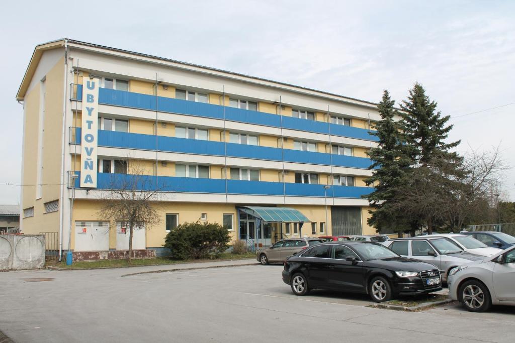 a large building with cars parked in a parking lot at Hostel Turist in Zvolen