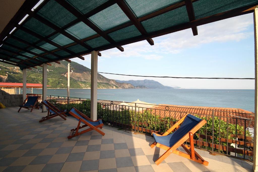 a porch with chairs and a view of the ocean at Apartments Savina in Budva
