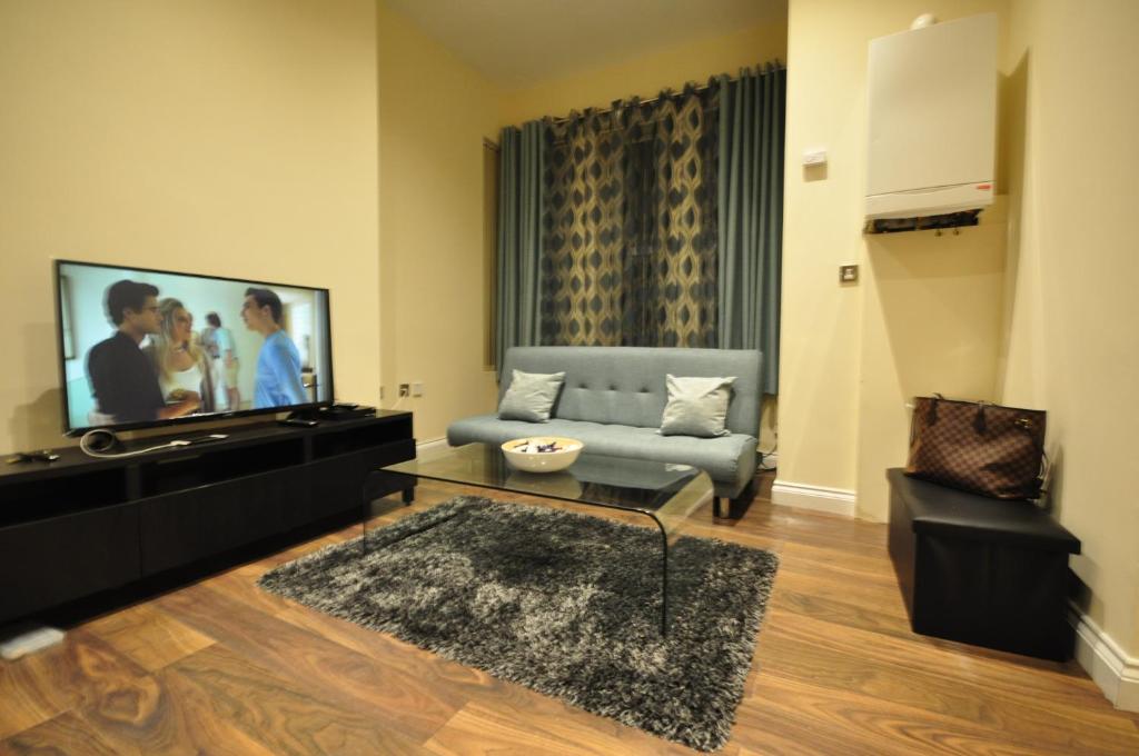 ein Wohnzimmer mit einem Sofa und einem Flachbild-TV in der Unterkunft Luxurious 2 Bed Apartment in Bedford