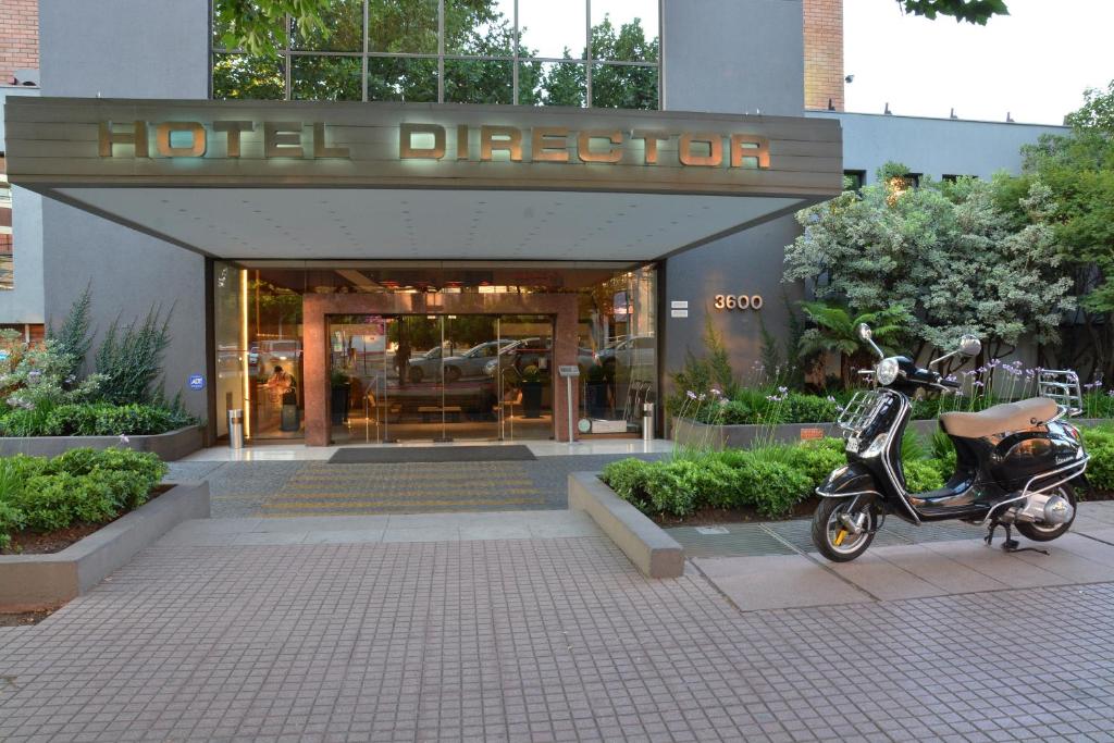 un scooter estacionado frente a un edificio en Hotel Director Vitacura, en Santiago