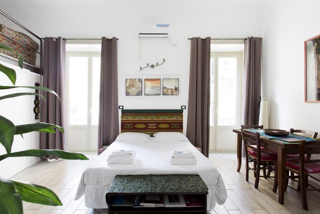 a bedroom with a bed and a desk and a table at Maqueda Apartments in Palermo