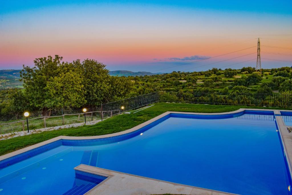 モーディカにあるAgriturismo Villa Gaiaの夕日を背景に見えるスイミングプール