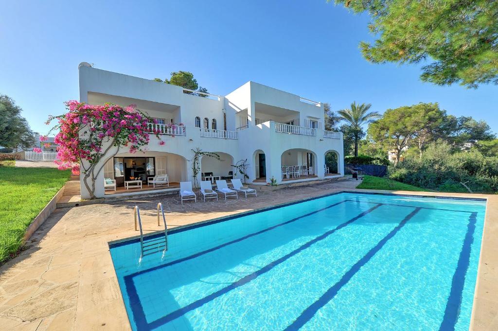 a villa with a swimming pool in front of a house at Villa Vistamar in Cala d´Or