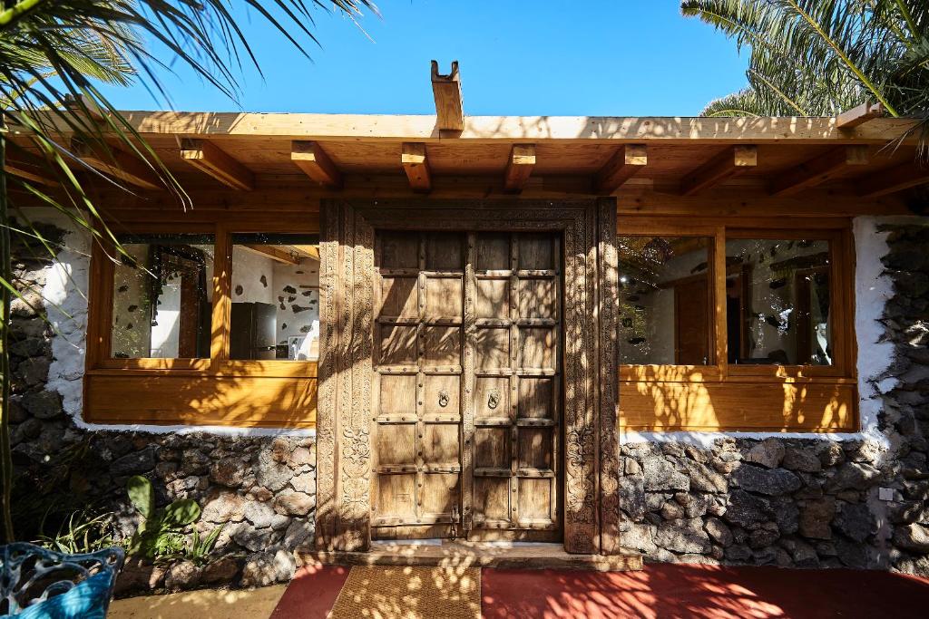 une maison avec une porte et des fenêtres en bois dans l'établissement Villa Palmeras Canarias, à Uga