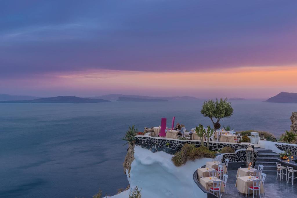 restauracja z widokiem na ocean o zachodzie słońca w obiekcie Andronis Luxury Suites w mieście Oia
