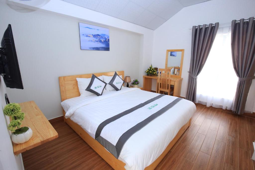 1 dormitorio con 1 cama grande y TV en Moc Tra Hotel en Da Lat