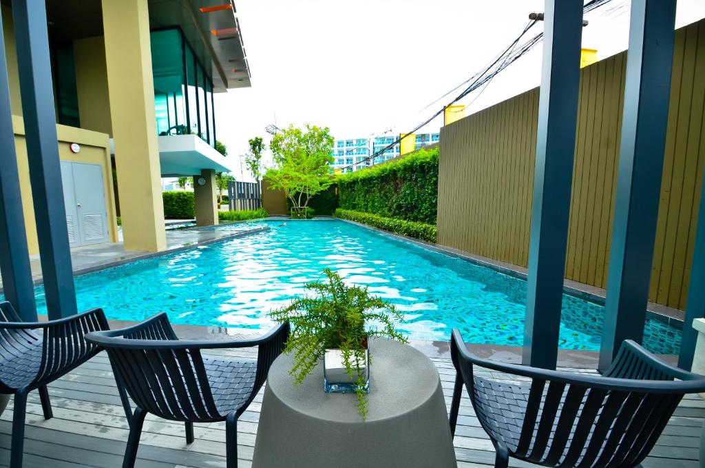 a swimming pool with chairs and a table in a building at Baan Imm Aim Condo Hua Hin in Hua Hin