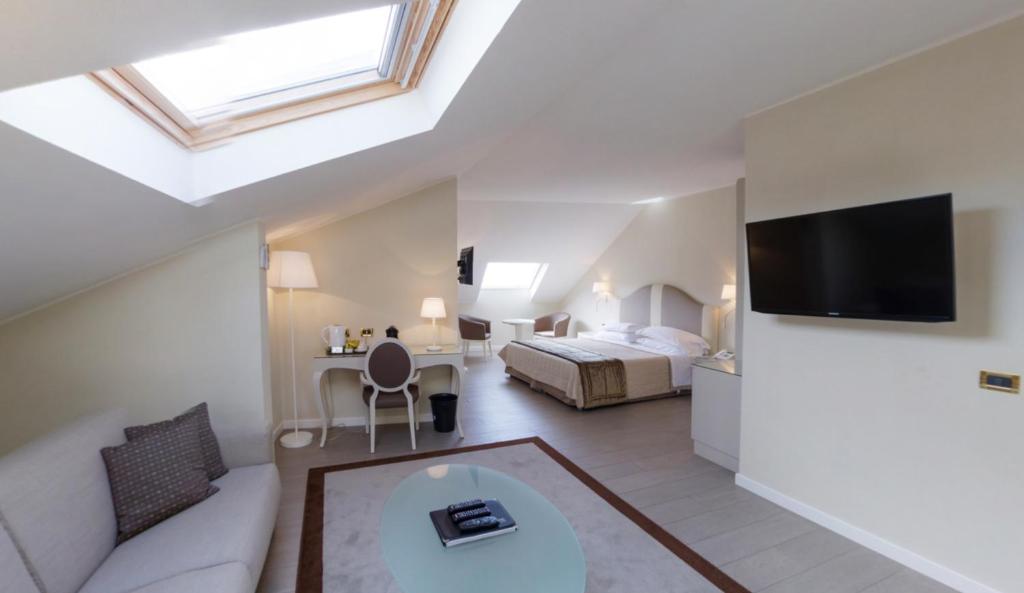 a loft bedroom with a bed and a living room at Hotel Miramare & Spa in Sestri Levante