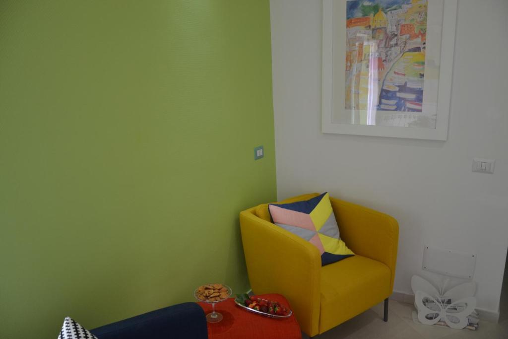 a yellow chair in a room with green walls at Terra Murata Boutique b&b in Procida