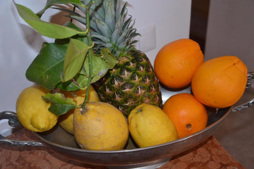 a metal bowl filled with fruit on a table at Terra Murata Boutique b&b in Procida