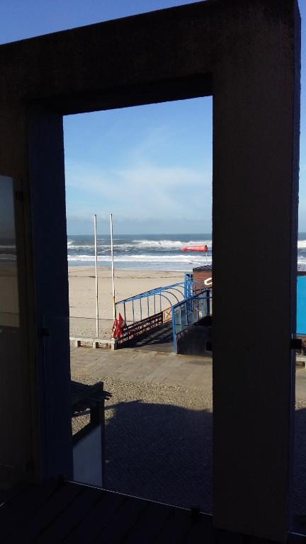 Blick auf den Strand von einem Fenster eines Gebäudes in der Unterkunft Casa Vista Mar Torreira in Torreira