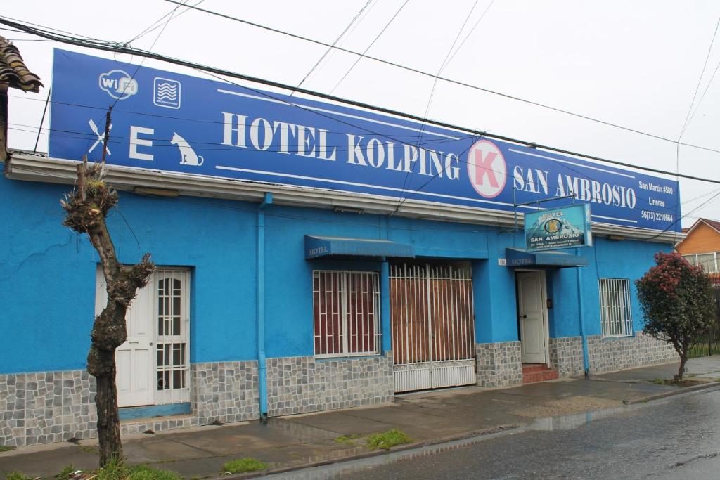 un bâtiment bleu avec un panneau sur son côté dans l'établissement Hotel Kolping San Ambrosio, à Linares
