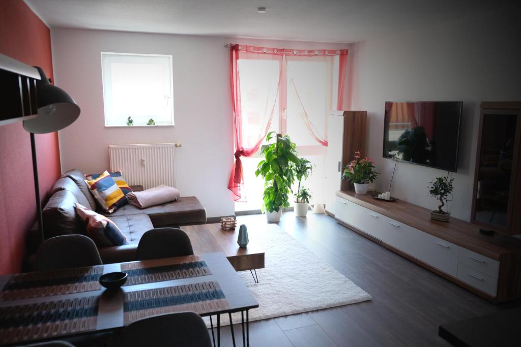 a living room with a couch and a tv at Apartment von Betzenstein in Markkleeberg