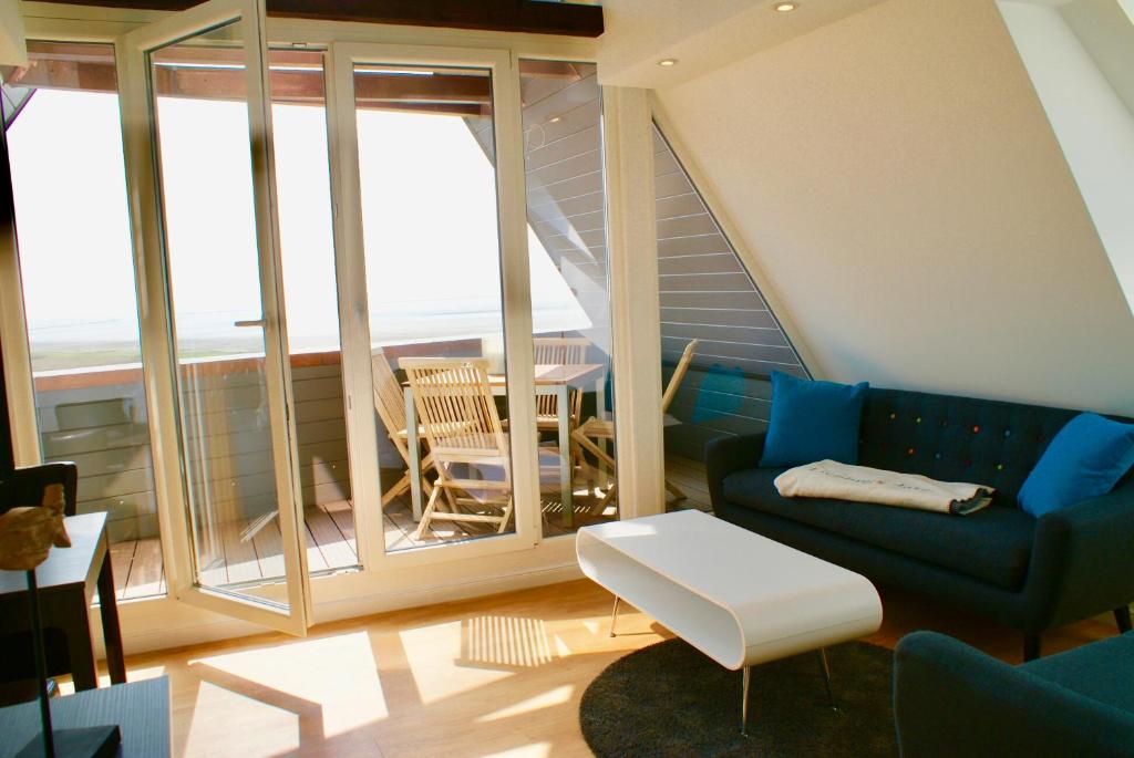 a living room with a couch and a table at Deichhotel Rose in Juist
