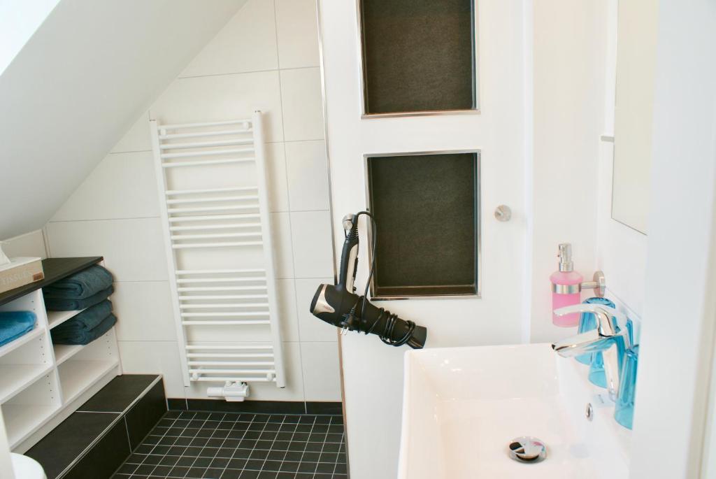 a small bathroom with a sink and a mirror at Deichhotel Rose in Juist
