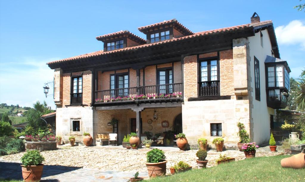 a large brick house with a balcony in a yard at Posada Andariveles in Quijas