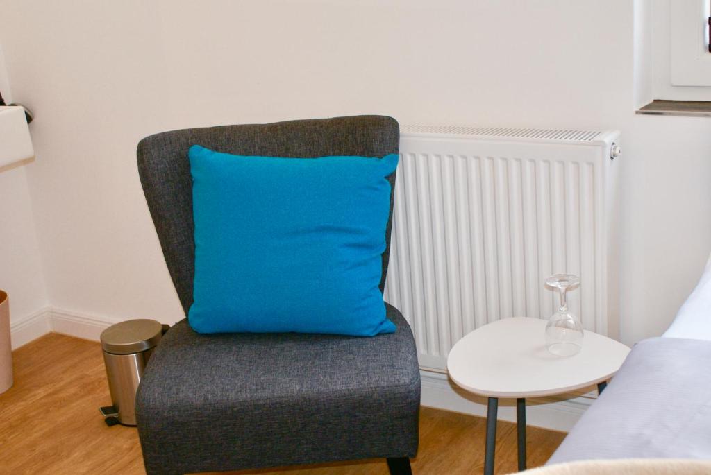 a blue pillow sitting on a chair in a bedroom at Deichhotel Rose in Juist