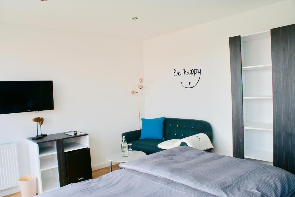 a bedroom with a blue bed and a tv at Deichhotel Rose in Juist