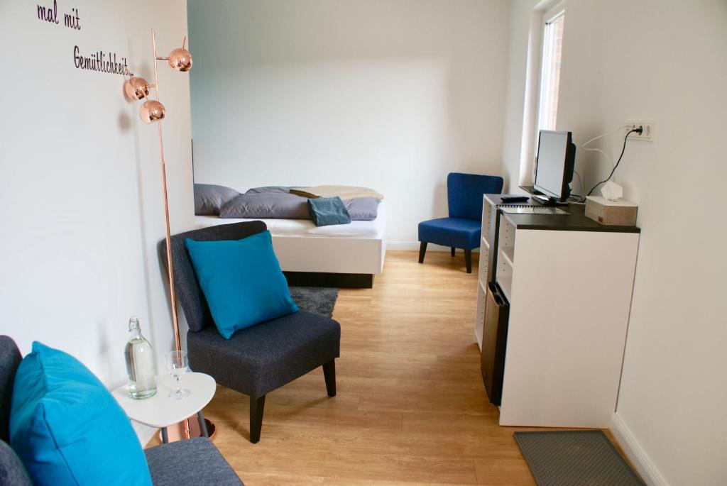 a small living room with a couch and a bed at Deichhotel Rose in Juist