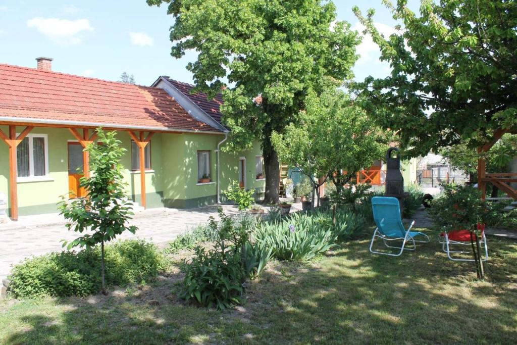 een huis met een tuin met een blauwe stoel bij Homoky Pincészet és Vendégház in Tállya