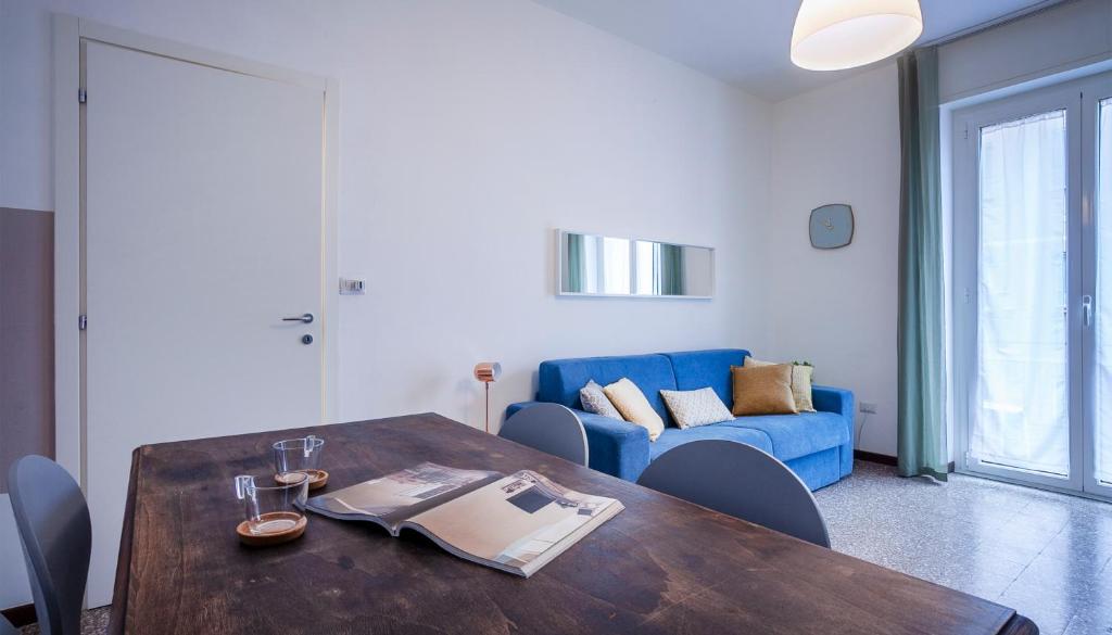 een woonkamer met een tafel en een blauwe bank bij Italianway-Abba in Milaan