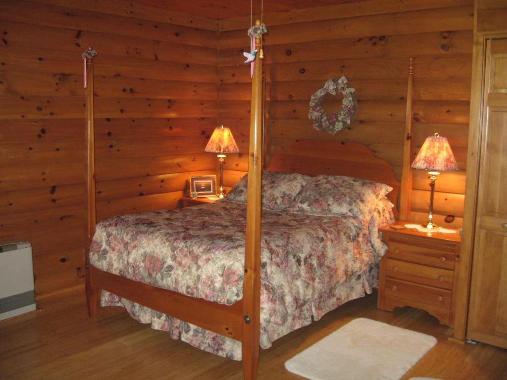 a bedroom with a bed in a log cabin at Serenity On The Lake in Auburn