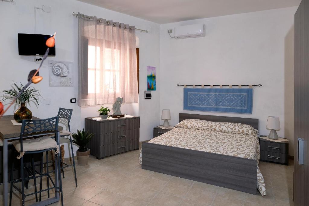 sypialnia z łóżkiem, biurkiem i krzesłem w obiekcie Bed & Breakfast L'Aquilino w mieście Iglesias