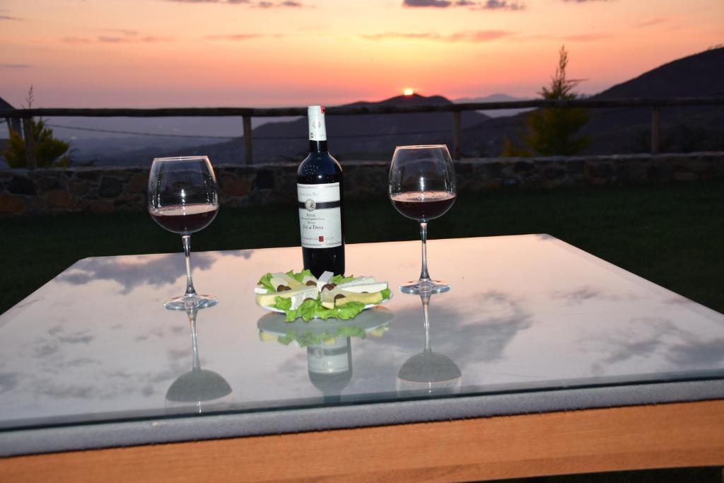 a table with two wine glasses and a bottle of wine at Sofra E Shpatit in Elbasan