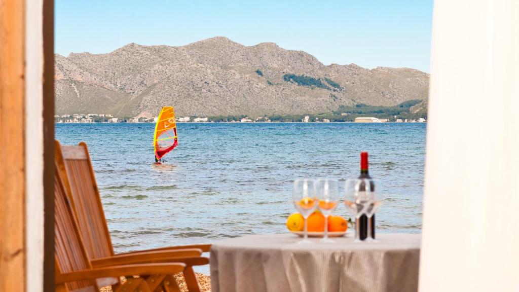 a table with wine glasses and a sail in the water at Sa Marina / Sa Marina 7A in Alcudia