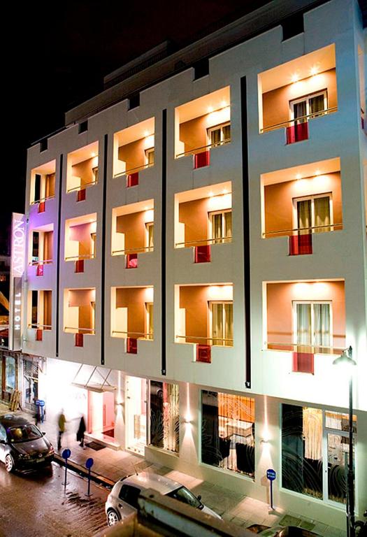 a lit up building with cars parked in a parking lot at Hotel Astron in Kardítsa