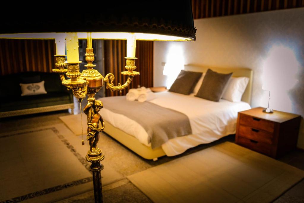 a bedroom with a large bed and a lamp at Domvs Gaia GHouse B&B in Vila Nova de Gaia