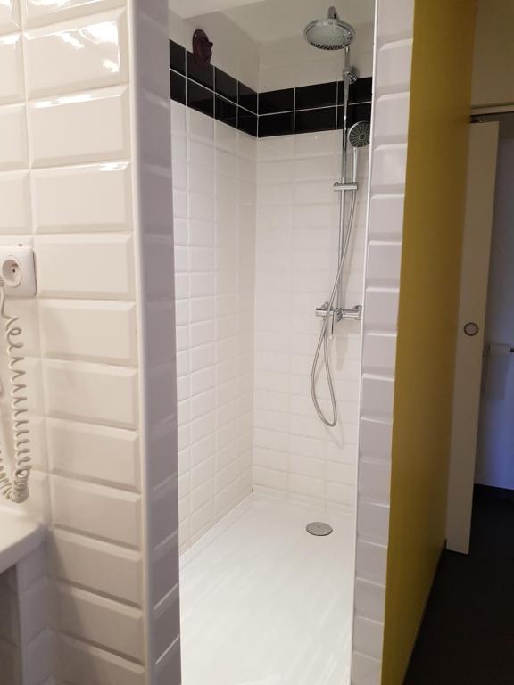 a bathroom with a shower with white tiles at Hotel le Corbusier in Marseille