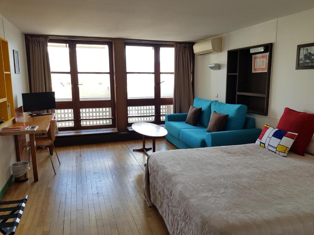 a hotel room with a bed and a couch at Hotel le Corbusier in Marseille