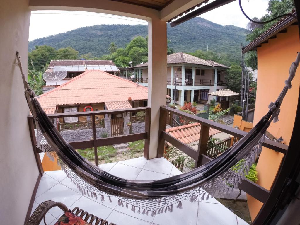 a hammock on the balcony of a house at Pousada Recanto do Sabiá in Abraão