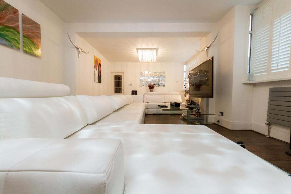 a large white living room with white furniture at Juzz Holiday Lets in London