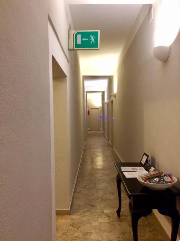 a hallway with a sign on the wall and a table at Residence Ducale in Rodi Garganico