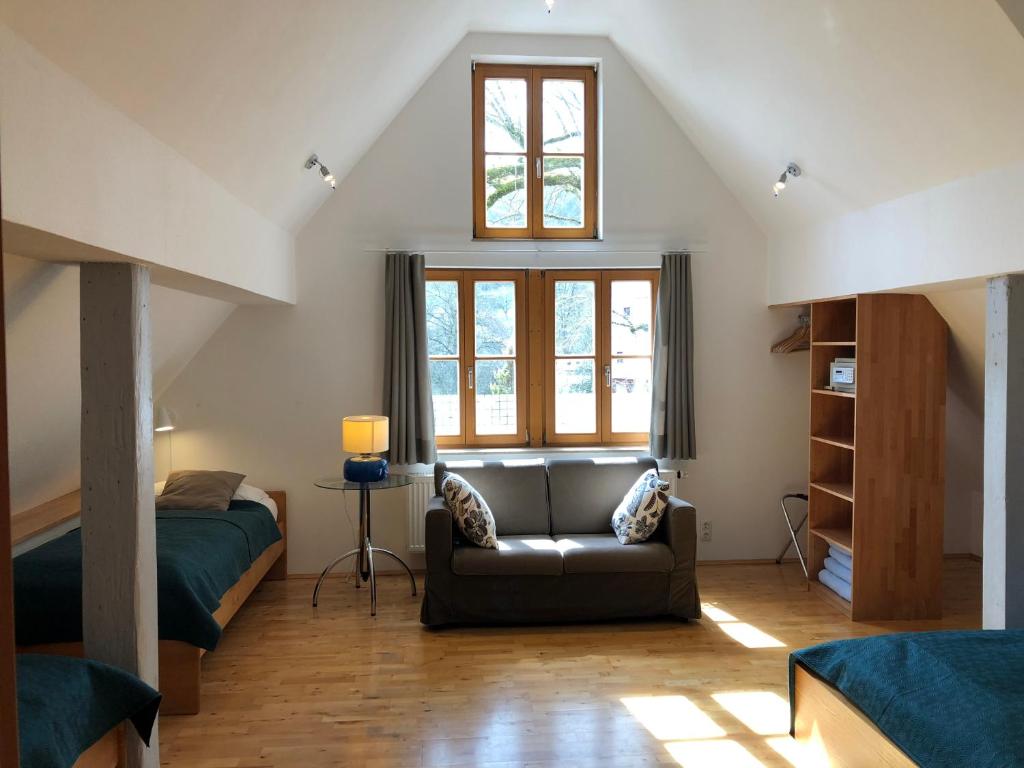 a living room with a couch and a bed at Pension Fuchsmühle in Rothenburg ob der Tauber