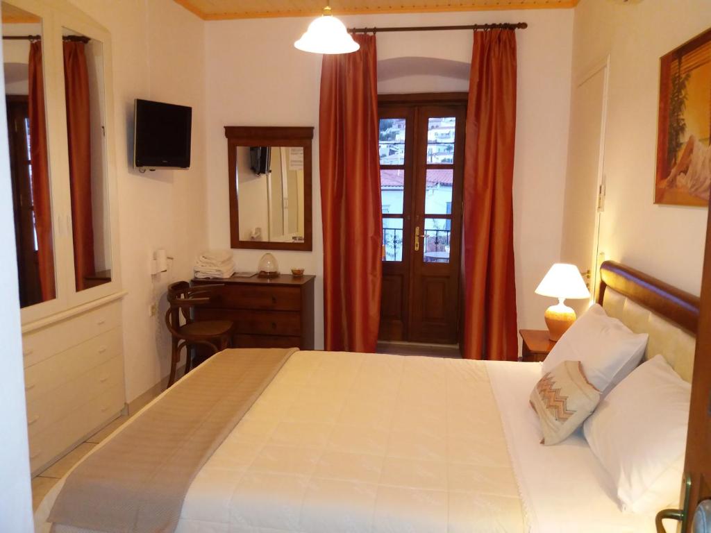 sypialnia z łóżkiem, biurkiem i oknem w obiekcie Perakis Apartments w mieście Hydra