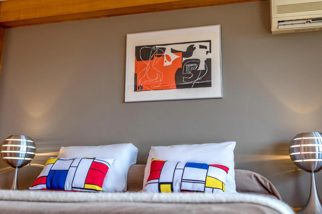 a bedroom with a couch with pillows and a picture on the wall at Hotel le Corbusier in Marseille