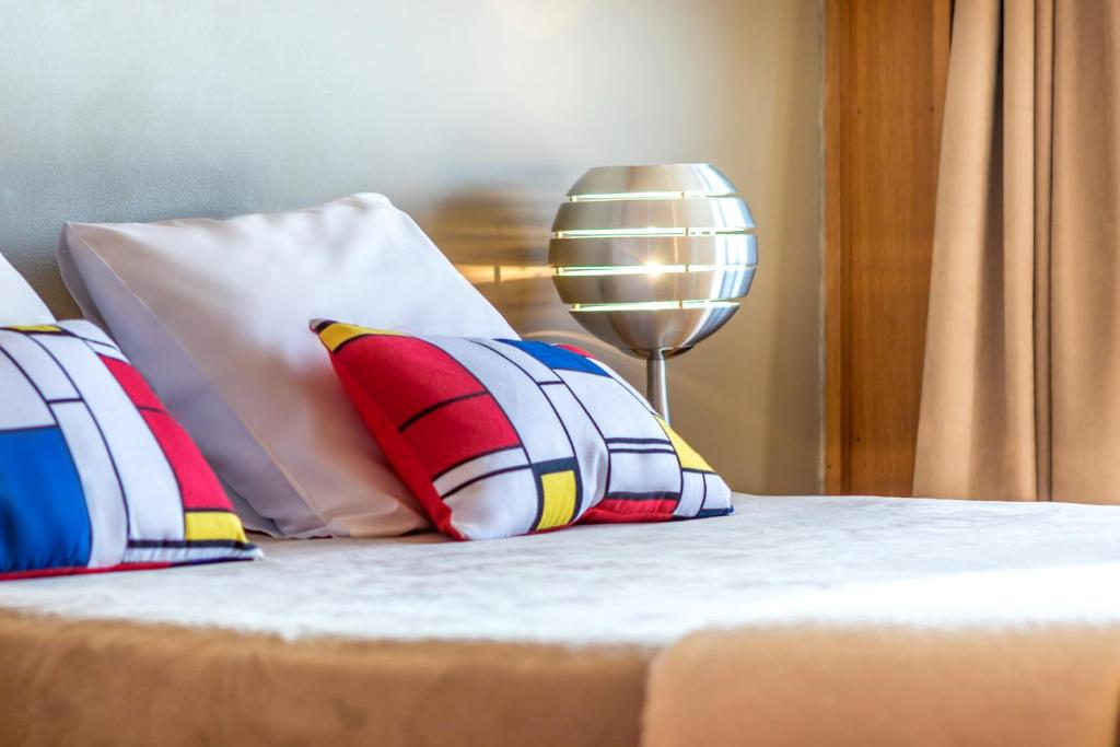 a bed with pillows and a lamp on it at Hotel le Corbusier in Marseille