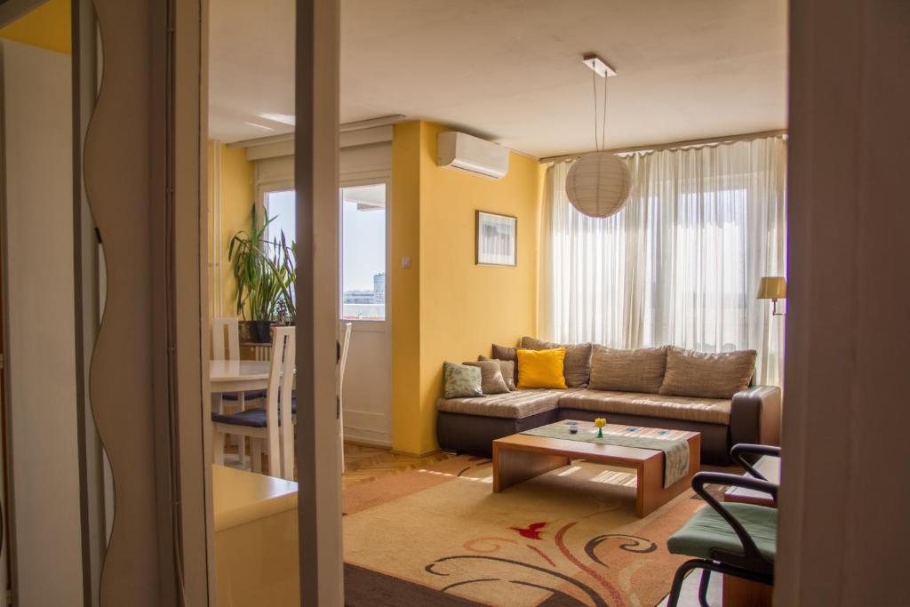 een woonkamer met een bank en een tafel bij Sunny Apartment in Belgrado