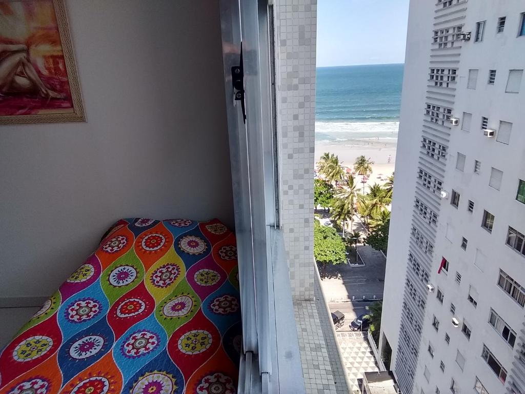 a bedroom with a view of the beach from a balcony at Apto pé na areia Praia das Pitangueiras - Centro in Guarujá