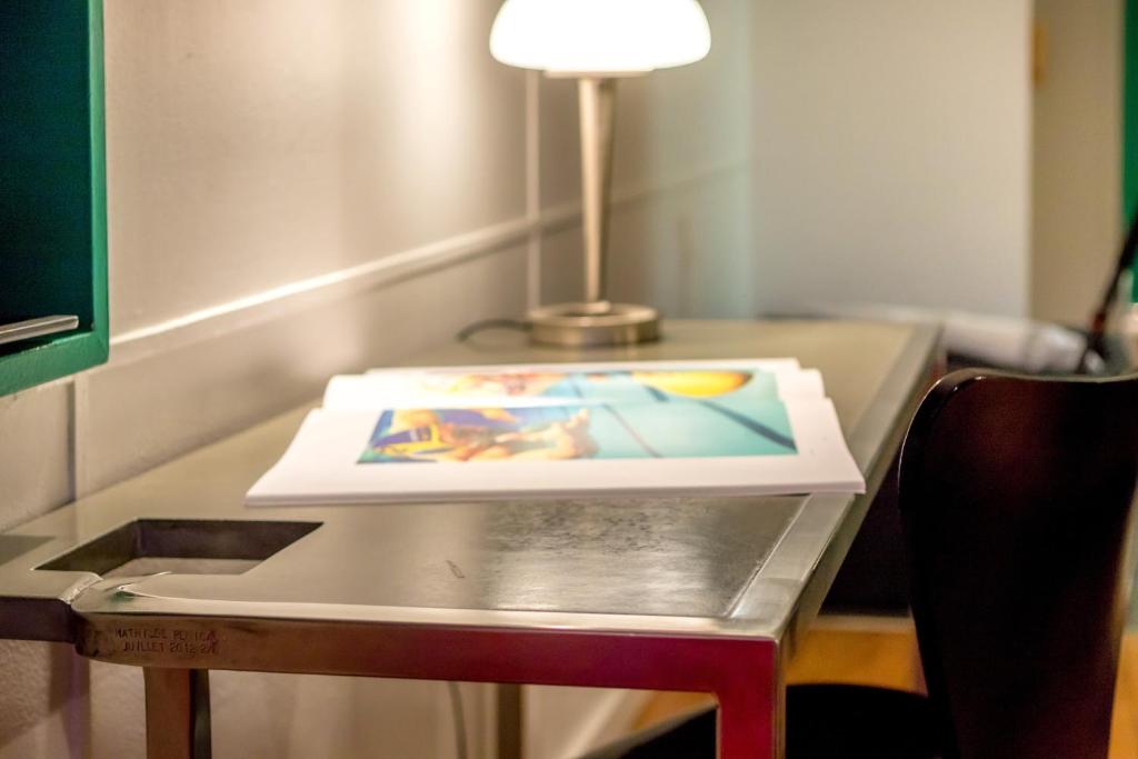 a table with a lamp and a picture on it at Hotel le Corbusier in Marseille