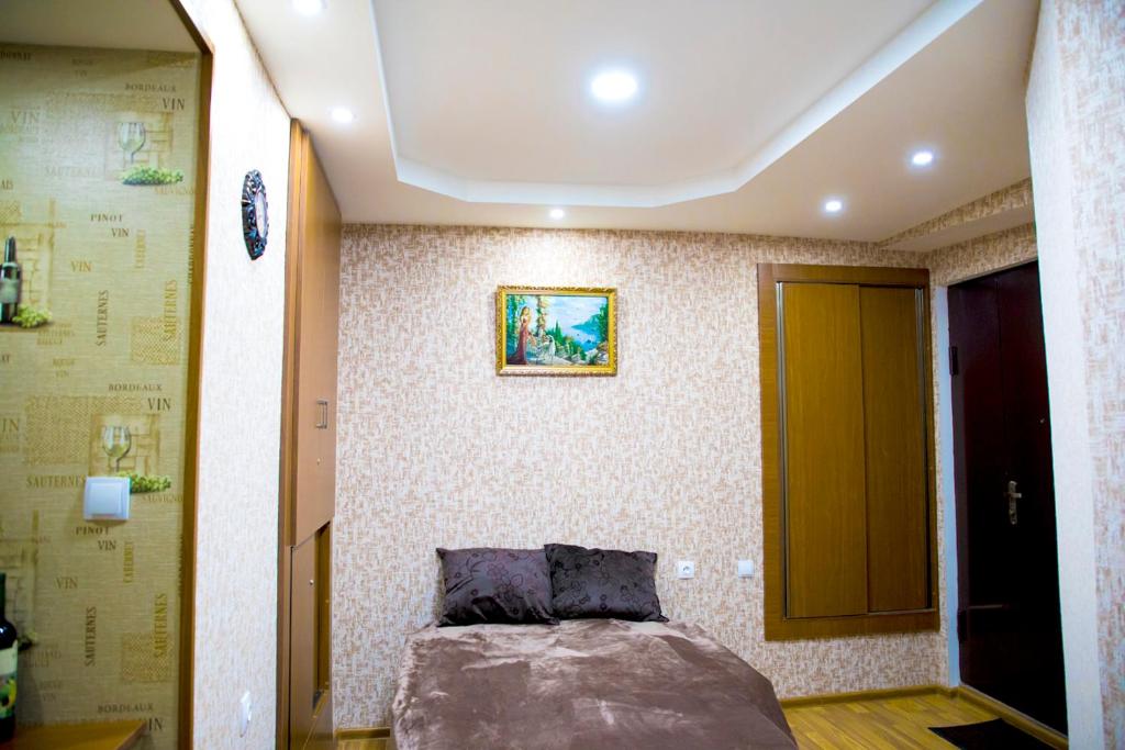 第比利斯Absolute Apartment的卧室位于客房的角落,配有一张床