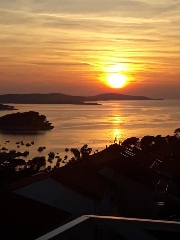 una puesta de sol sobre un cuerpo de agua con la puesta de sol en B&B Buzolic, en Hvar