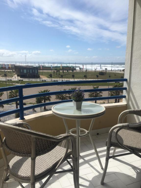 - Balcón con mesa y sillas y vistas a la playa en Paradise en Costa da Caparica