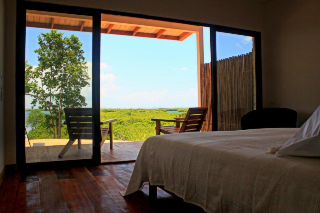 博卡斯德爾托羅的住宿－維拉食宿度假村，一间卧室设有一张床和一个滑动玻璃门