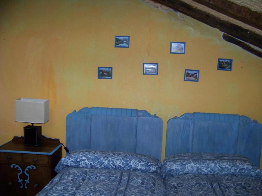 een slaapkamer met een bed en foto's aan de muur bij B&B El Jardín de Aes in Puente Viesgo