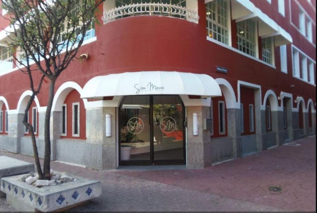 un bâtiment rouge avec un auvent blanc devant un magasin dans l'établissement San Marco Hotel Curacao & Casino, à Willemstad