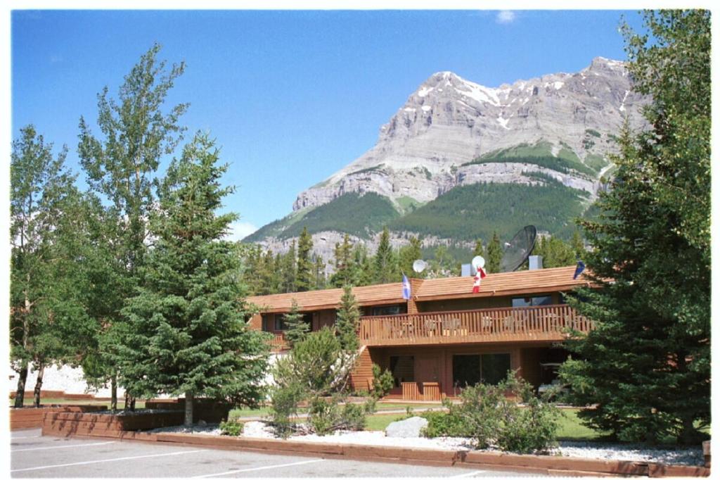 a person standing on top of a building with a mountain at The Crossing in Saskatchewan River Crossing